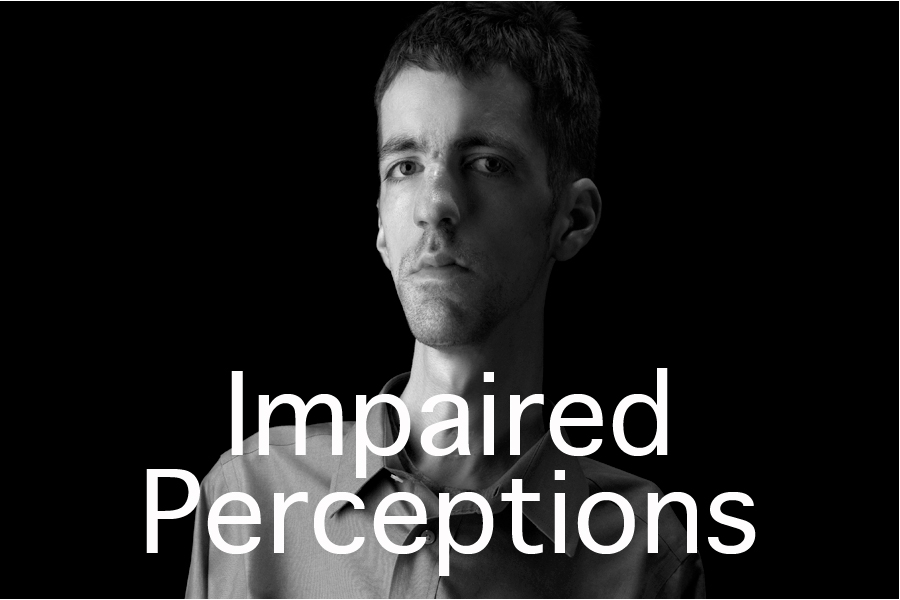 Impaired Perceptions button. This is a black and white photographic portrait of photographer Brian Charles Steel.  Steel has congenital fiber type disproportion, which causes him to be thin and small framed.  Steel is positioned on the right side of the frame and he fills it from top to bottom on that side.  You see him from just above the knees and up.  He is wearing a long sleeved dress shirt with dress slacks.  His arms are at his side and he is looking straight into the camera.  He is lit in a Rembrandt style with the main light source coming from the left. 