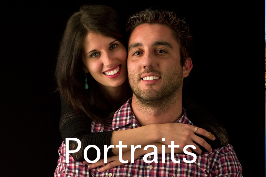 Portraits button. This is a Brian Charles Steel photograph of Kyle and Nikki.  Nikki is behind Kyle with her arms around him while hanging over his shoulders with her face beside his. They are both smiling, and looking into the camera.  She has long brown hair, and he has short curly hair.  They are towards the right side of the frame, and are seen from the chest up.  The background is solid black. 