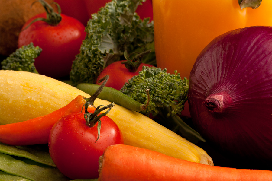 This is a Brian Charles Steel photograph of vegetables.  The vegetables fill the frame.  In the front part of the image is a carrot on the right.  A small tomato is to the left of the carrot.  To the left and in front of the tomato are pea pods.  Behind the tomato is a jalapeño pepper. Behind the tomato is a yellow squash.  To the right of the squash is a purple onion and beside the onion is broccoli. Behind the broccoli are a yellow dell pepper and a red pepper.  The photograph is lit from behind.  All of the veggies are in focus.  In this photograph I used complementary colors and contrasting textures to make a vibrant photograph. 