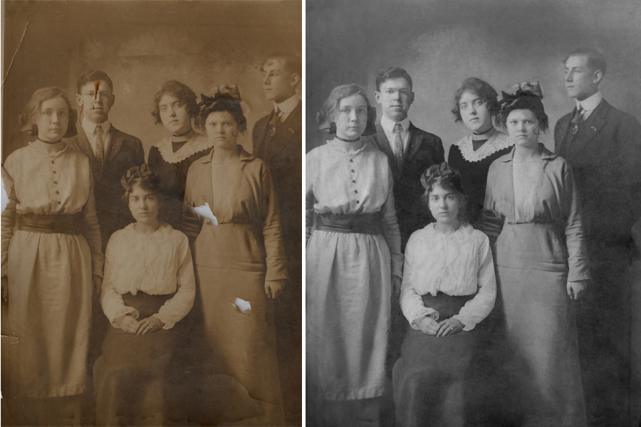 This an example of a photograph restored by Brian Charles Steel Photography.  It is an old group portrait of six people.  There are four women and two men.  In the front, is one woman wearing a white blouse and dark skirt.  She has her hair up, and her hands are folded neatly in her lap.  Standing behind her on the left side, is a woman in a light colored dress.  Her hands are down by her sides.  The top front of her dress has buttons.  Behind her to the right is a man in a suit and tie.  Next to him on his right, is a woman in a dark dress with a white collar.  To her right is a man in a suit and tie.  In front of him, is a woman in a dress with a hat. 